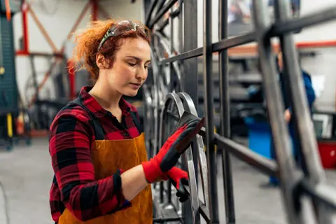 Weiblicher Azubi bei Metallarbeiten in der Werkstatt