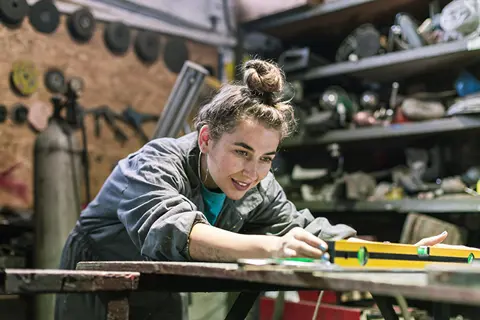 Junge Frau arbeitet mit Wasserwaage