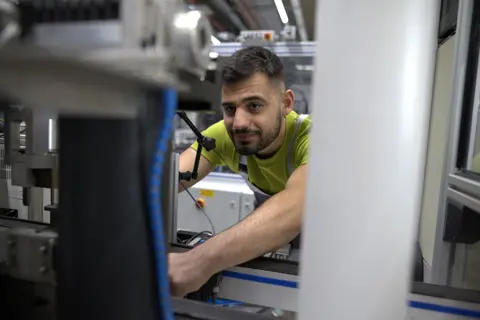 Junger Industriemechaniker bei der Arbeit an einer Maschine