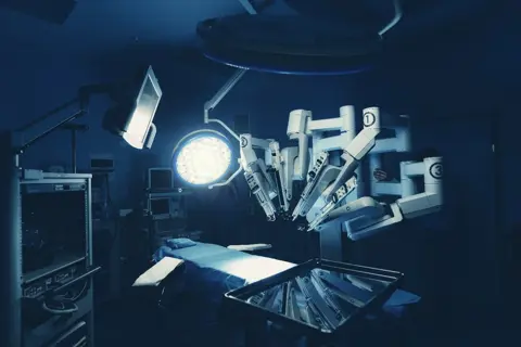 Chirurgischer Raum im Krankenhaus mit Robotertechnik, Maschinenarm-Chirurg im futuristischen Operationssaal. Minimalinvasive chirurgische Eingriffe, medizinische Roboterchirurgie mit 3D-Ansicht Endoskopie